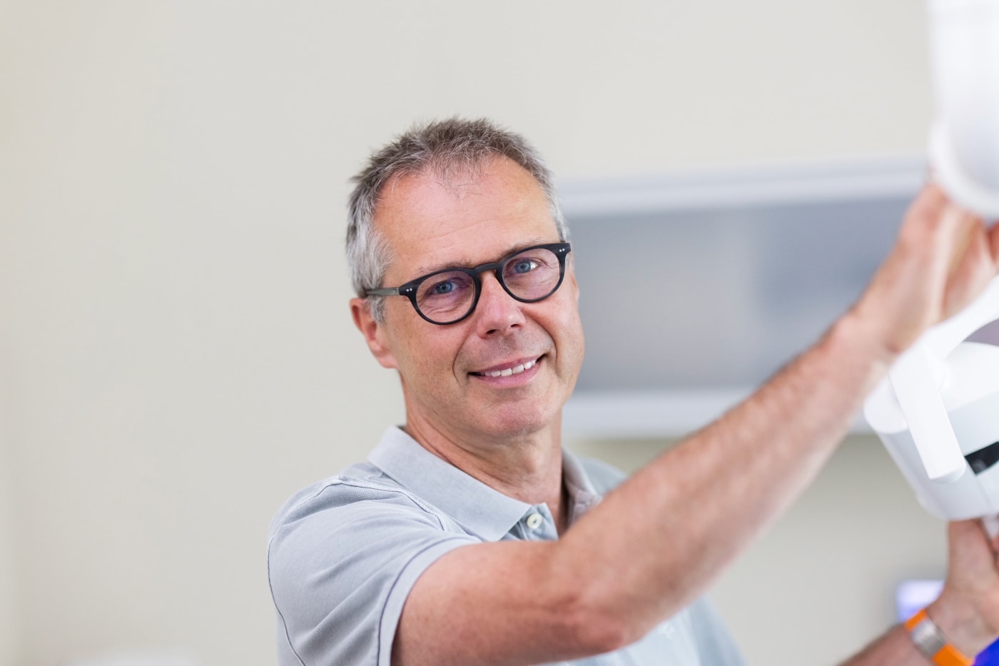 älterer Mann mit Brille und grauem Shirt